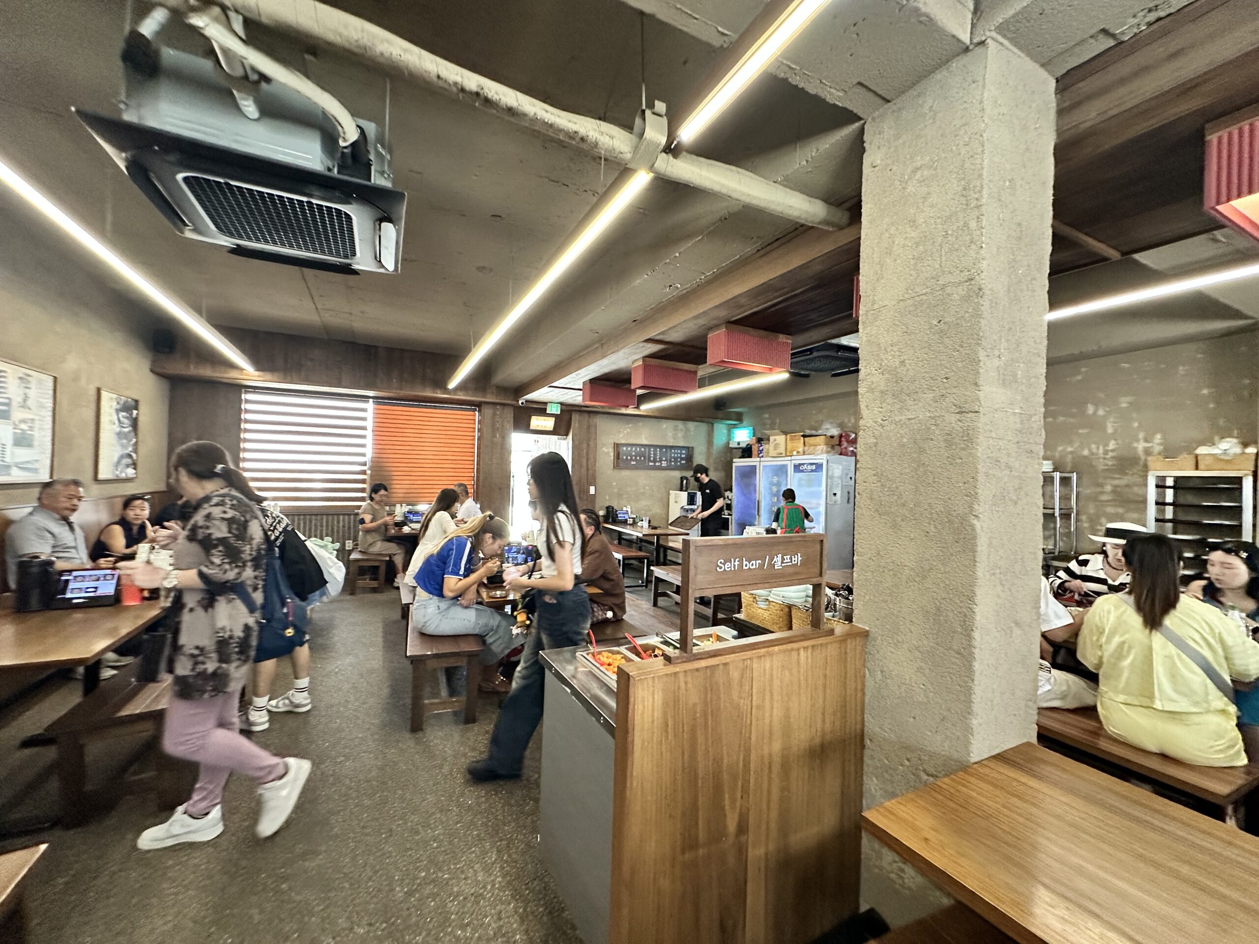 Inside a busy local Korean restaurant in Busan filled with locals, with a self-serve side dish bar